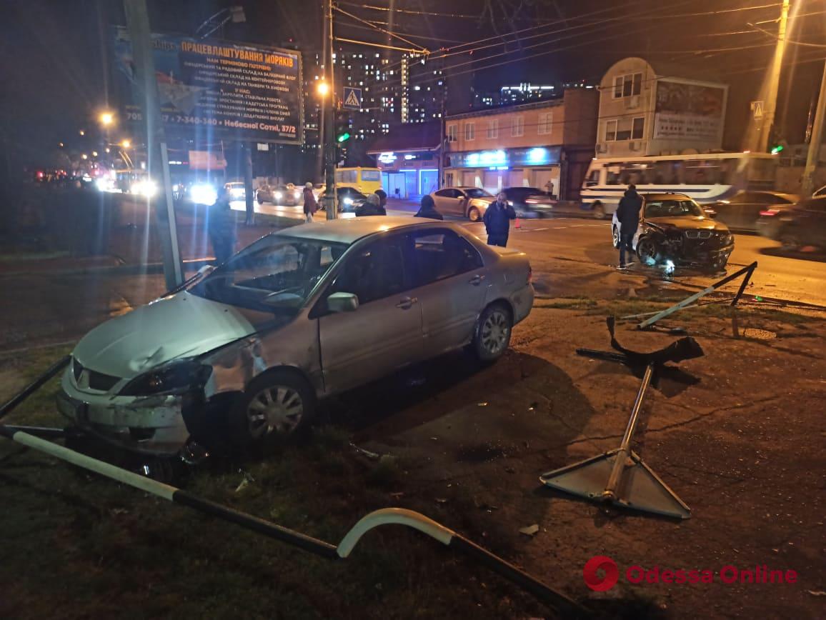 На Таирова столкнулись два авто: Mitsubishi снес забор и дорожный знак