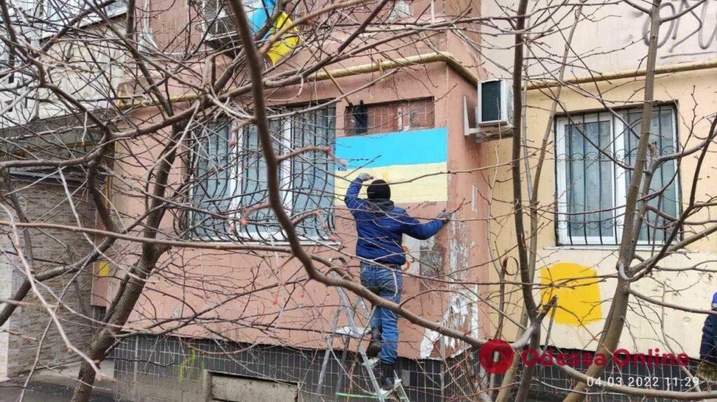 Одесские коммунальщики помогают горожанам рисовать на домах национальную символику