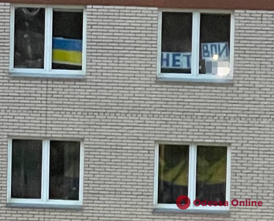На россии жильцам дома в Красноярске коммунальщики закрасили окна из-за флага Украины и плаката “Нет войне” (видео)